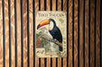 A vintage-style poster of a toucan, featuring a detailed illustration of the bird and its natural habitat, is displayed on a wooden wall.