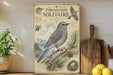 a vintage-style poster of a bird, specifically a bluebird, perched on a branch with pine cones and a nest, set against a backdrop of mountains and a lake.