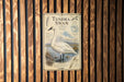 a poster of a white swan with a detailed illustration and text, mounted on a wooden wall.