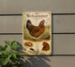 A metal sign with an illustration of a chicken and eggs, mounted on a wall next to a plant.