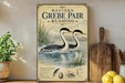 A vintage-style poster advertising the Western Grebe, a type of water bird, with illustrations of the bird in water and a wooden paddle on a shelf.