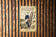 a poster of a white-headed woodpecker hanging on a wooden wall.