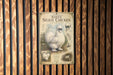 A vintage-style poster of a white Silkie chicken is displayed on a wooden wall.
