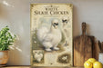 a poster or painting of a white Silkie chicken, which is a breed of chicken known for its distinctive appearance and elegant demeanor. The poster includes a detailed illustration of the chicken, along with text that provides information about the breed, such as its origin, traits, and history. The poster is displayed on a shelf, surrounded by various kitchen items, including a wooden cutting board, a potted plant, and a bowl of fruit.