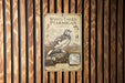 a vintage-style poster or sign with illustrations and text, mounted on a wooden wall.