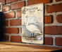 a vintage-style illustration of a swan, mounted on a brick wall.