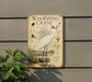 a metal sign with illustrations and text about a Whooping Crane, mounted on a wall next to a plant.