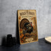 a wooden sign with a turkey illustration, placed on a table next to some black camera lenses.