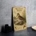 A vintage-style metal plaque featuring an illustration of a bird, likely Wilson's Snipe, standing in a natural setting.