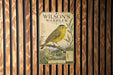A vintage-style poster of a yellow warbler bird is displayed on a wooden wall.