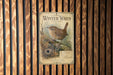 A vintage-style poster of a small brown bird, likely a wren, perched on a branch, is displayed on a wooden wall.