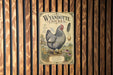 A vintage-style poster of Wyandotte chicken is displayed on a wooden wall.