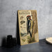 A metal poster titled "Yellow-bellied Sapsucker" is displayed on a table, featuring illustrations and information about the bird.