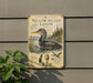 A metal sign with a detailed illustration of a yellow-billed loon, surrounded by text and images related to the bird.