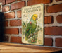 A vintage-style poster of a yellow-headed Amazon parrot is displayed on a brick wall, with a wooden table below it.
