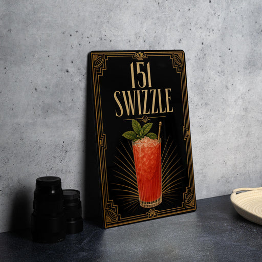 a framed cocktail illustration with a swirled drink and a green leaf garnish, placed on a gray countertop next to a stack of black containers.