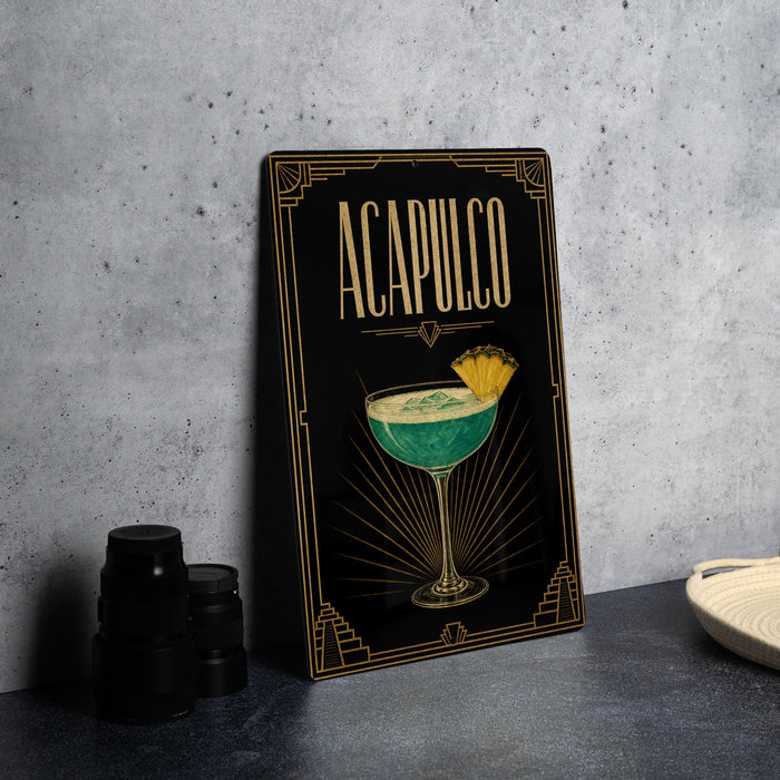 a framed illustration of a cocktail glass with a tropical drink, placed on a countertop next to a stack of black camera lenses.