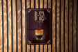 A sign with the text "B-52" and an image of a layered coffee drink is displayed on a wooden wall.