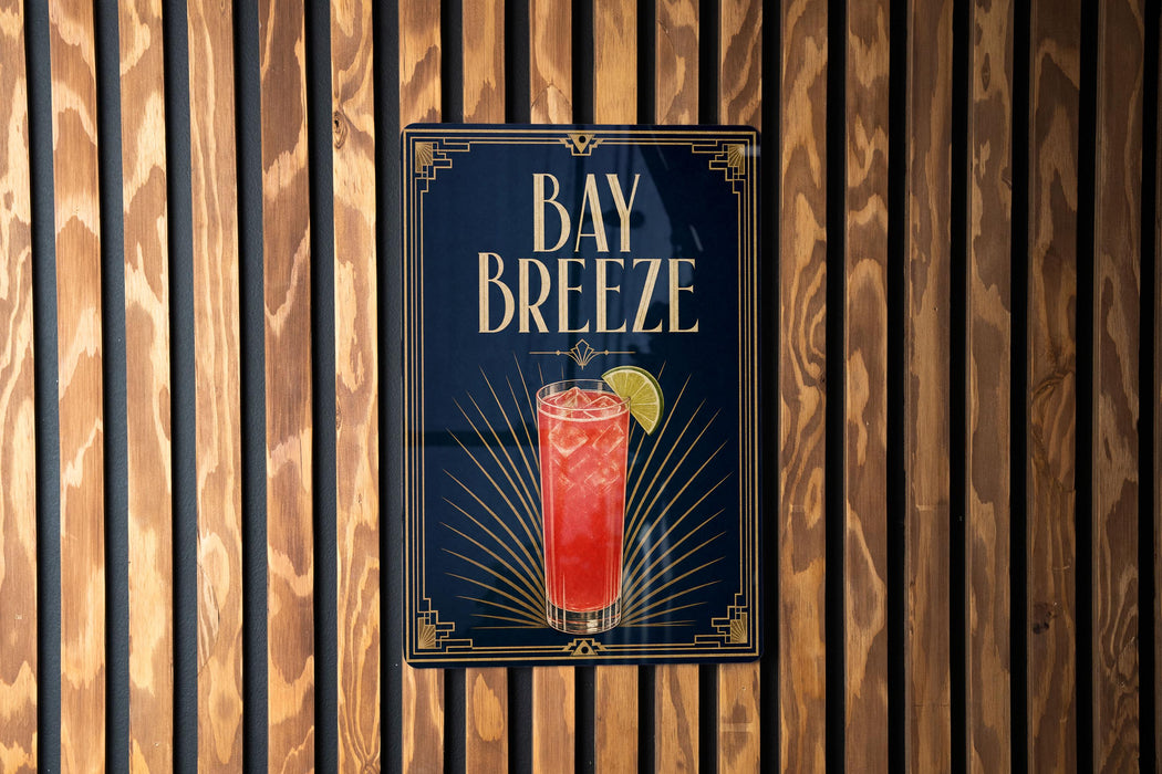 A sign for "Bay Breeze" cocktail is displayed on a wooden wall.
