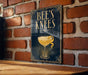 A poster with the text "BEE'S KNEE'S" and an illustration of a cocktail glass with a lemon twist.