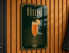 A sign for Bellini cocktail hanging on a wooden wall.