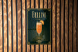 A poster with the word "Bellini" and an illustration of a glass of Bellini cocktail is displayed on a wooden wall.