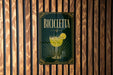A sign for a bar called "Bicyclette" with a glass illustration and decorative elements.