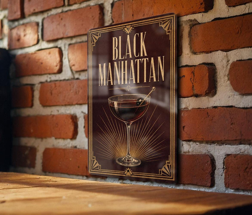 A sign with the text "BLACK MANHAITAN" and an illustration of a martini glass is displayed on a brick wall.