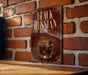 A sign with the text "Black Russian" and an illustration of a cocktail is displayed on a brick wall.