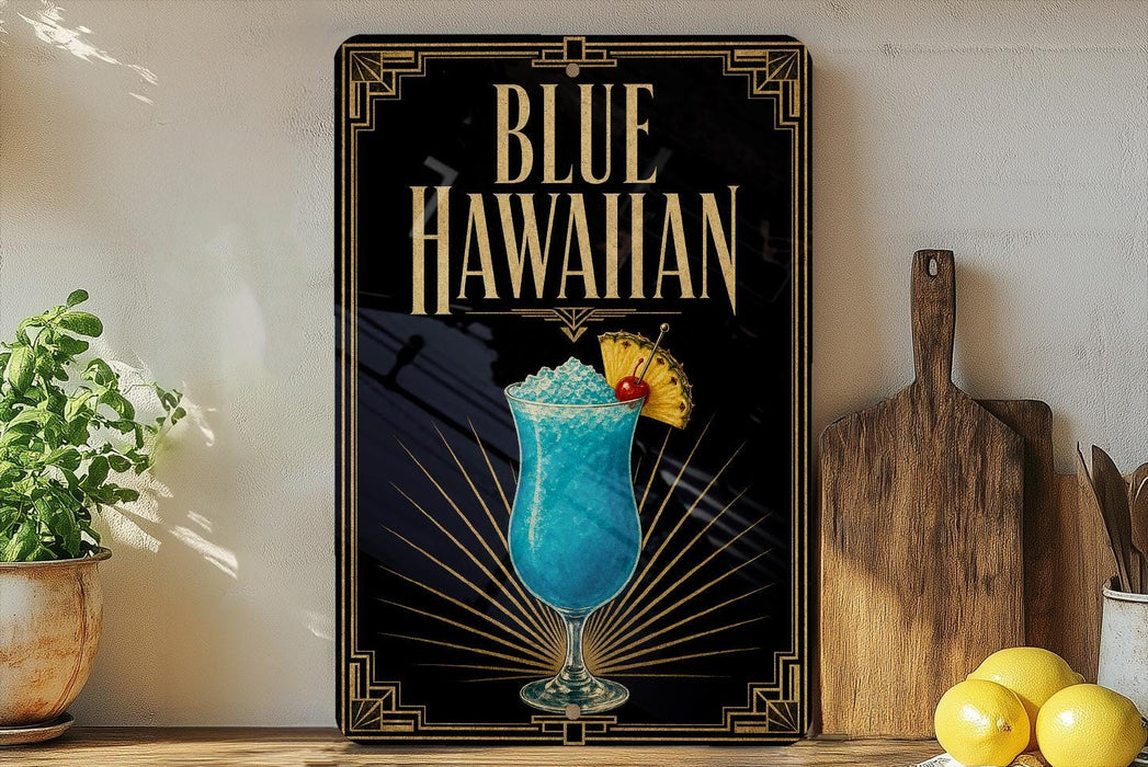 A framed advertisement for a Blue Hawaiian cocktail, featuring a blue drink with a straw and a yellow umbrella, placed on a wooden surface next to a wooden cutting board and a potted plant.