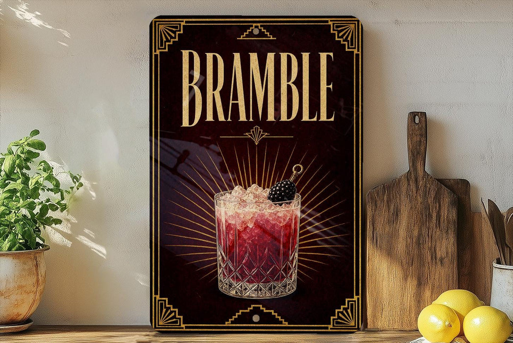 a decorative sign for a drink called "Bramble" with a glass of the drink and garnish, placed on a wooden surface next to a cutting board and some lemons.