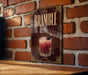 A decorative sign for a drink called "Bramble" is displayed on a brick wall.