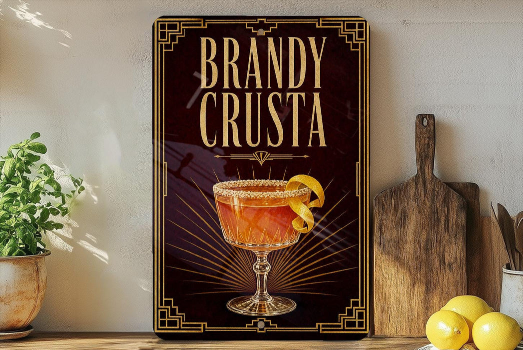 A framed advertisement for a Brandy Crusta cocktail, featuring an illustration of a glass with a lemon twist on the front.