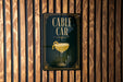 a sign for a bar called "CABLE CAR", which is displayed on a wooden wall.