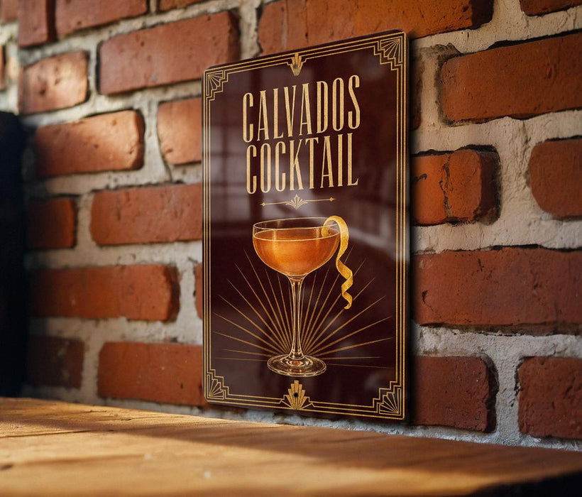 A framed poster of a cocktail on a brick wall, with the text "CALVADOS COCKTAIL" prominently displayed.