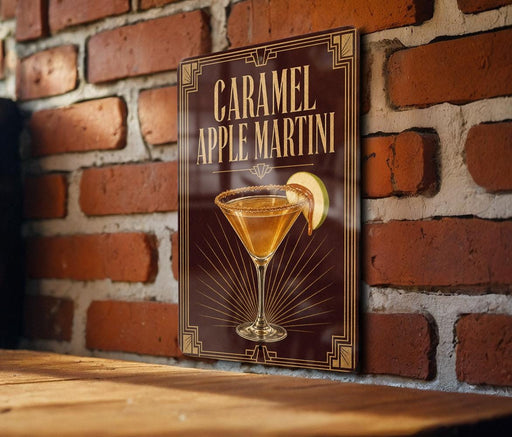 A sign for a caramel apple martini is displayed on a brick wall.
