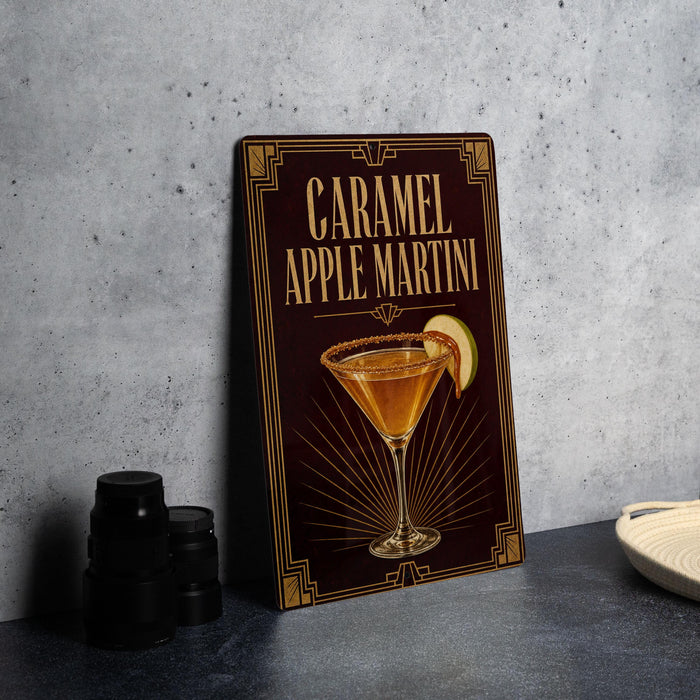 A framed image of a caramel apple martini on a wall, with a stack of black camera lenses and a white dish in the foreground.