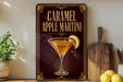 A decorative sign for a caramel apple martini, featuring an illustration of a martini glass with a slice of apple on the rim.