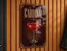 A decorative sign with the word "CARDINAL" prominently displayed, featuring an illustration of a martini glass with a cocktail garnish.