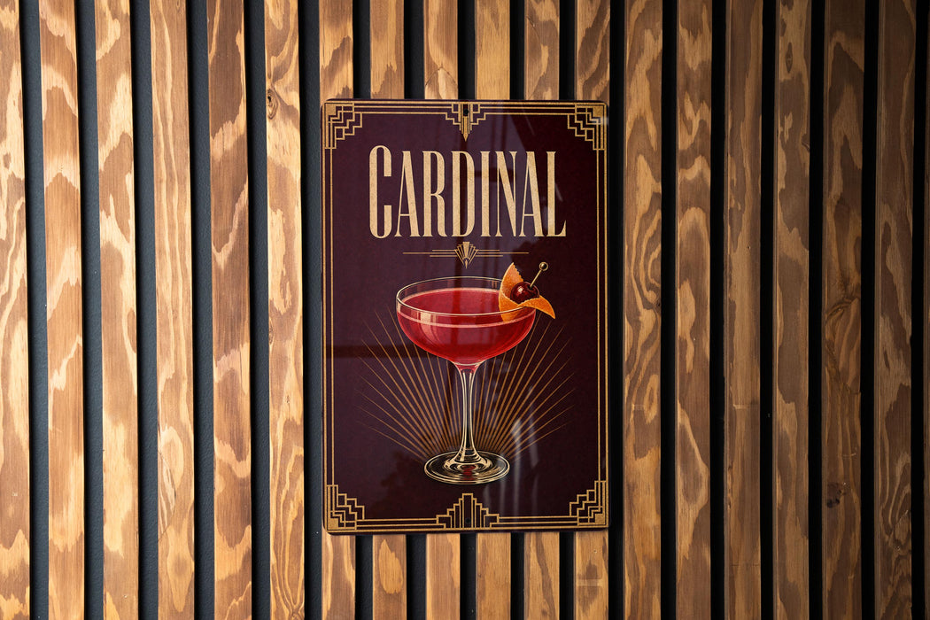 A sign for a "Cardinal" cocktail is displayed on a wooden wall.