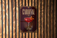 A sign for a "Cardinal" cocktail is displayed on a wooden wall.