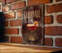 A decorative sign with the word "Cardinale" on it, featuring an illustration of a cocktail glass with a lemon twist.