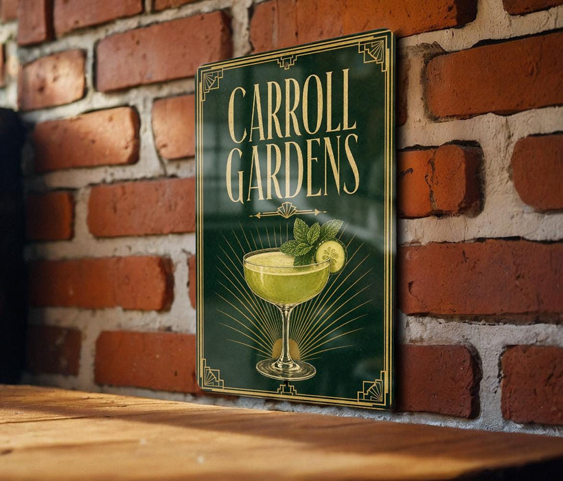 A sign for Carroll Gardens, featuring a cocktail glass with a lime garnish, is displayed on a brick wall.
