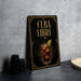 a framed poster with an illustration of a cocktail and the text "CUBA LIBRE" on it, placed on a countertop next to some black camera lenses.