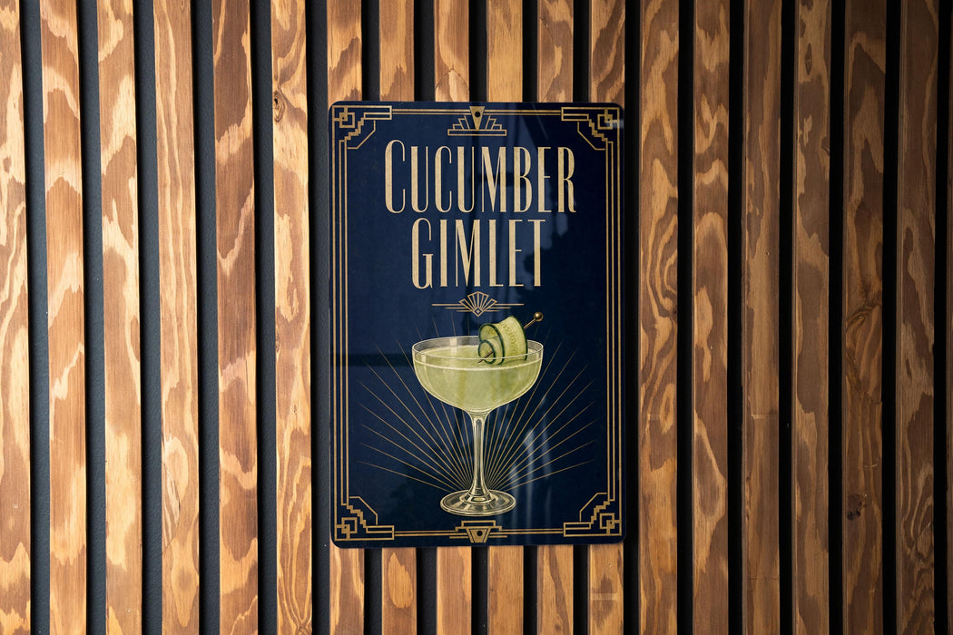 A sign for a cucumber gimlet cocktail is displayed on a wooden wall.