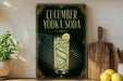 a decorative sign for cucumber vodka soda, with a glass illustration and text.