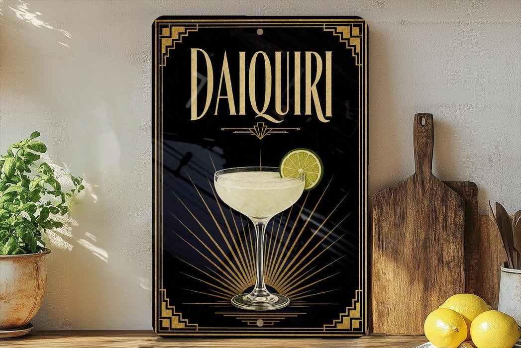 a decorative sign for a Daiquiri cocktail, with a glass of the cocktail and a lemon slice displayed on it. The sign is placed on a wooden surface, with a potted plant and a cutting board nearby.