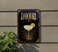 A decorative sign for a Daiquiri cocktail, featuring a glass of the drink and a lemon slice, is displayed on a wall.