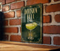 A sign with the text "DIVISION BELL" and an illustration of a cocktail glass with a lemon twist, mounted on a brick wall.