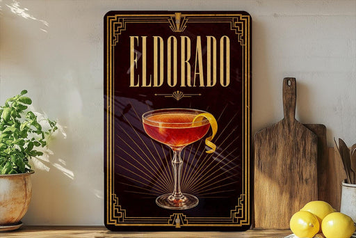 A framed poster of a cocktail called Eldorado, featuring a glass of the drink with a lemon twist, is displayed on a wall next to a wooden cutting board and some kitchen utensils.